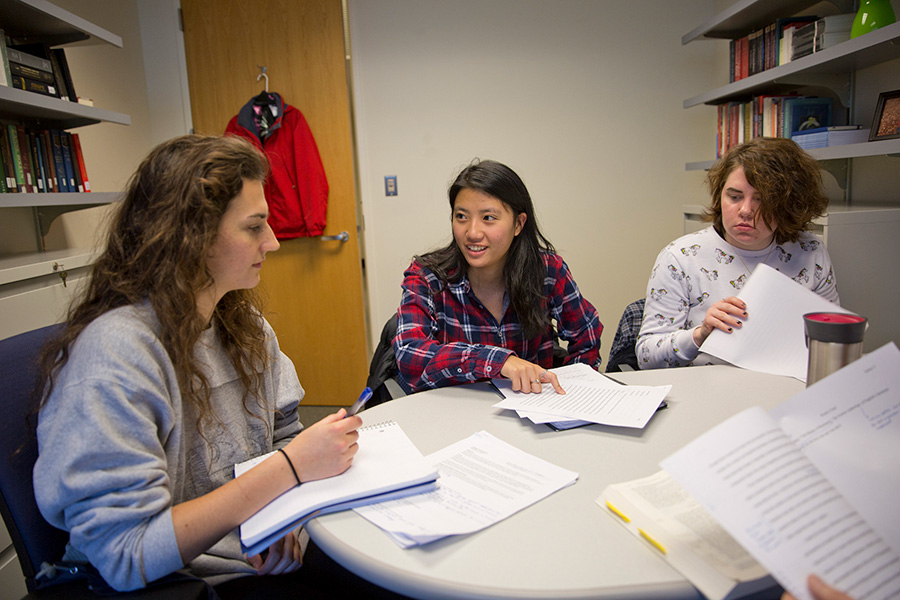 Three students discuss a topic during office hours.